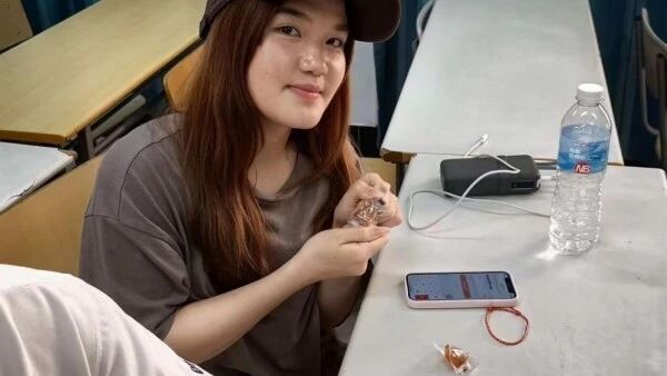 图为留学生品尝粽子糖和制作端午手链
