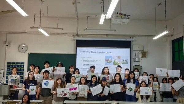 图为留学生展示自己设计的创意粽子图